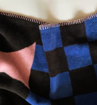 Designerski koc bawełniany Caregiver Black Donut, różowy w czarne pączki, geometryczny wzór od Hogai.