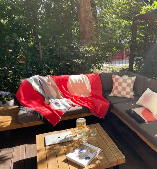 Designerska bawełniana narzuta na łóżko Surfer Baltic Red od Hogai. 165x210 cm – czerwono biały wzór inspirowany Bałtykiem. Aranżacja z poduszkami Hogai Chess i gradient