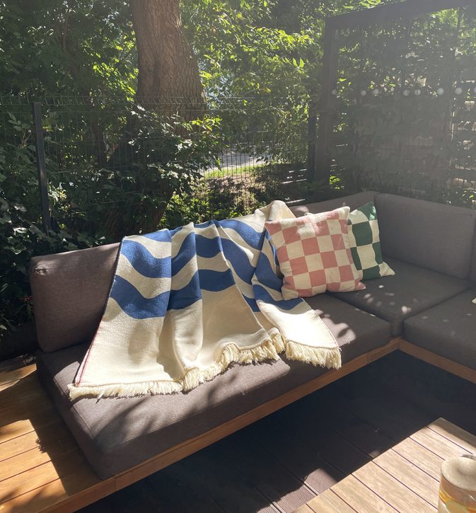 Designerska bawełniana narzuta na łóżko Surfer Baltic Blue od Hogai. 165x210 cm – różowo granatowy wzór inspirowany Bałtykiem. Aranżacja z poduszkami Hogai Chess.