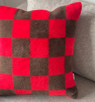 Puszysta poduszka w szachownicę Chess Red-Brown Hogai – miękka poduszka żakardowa w kolorze czerwonym i brązowym.