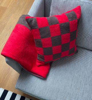 Puszysta poduszka w szachownicę Chess Red-Brown Hogai – miękka poduszka żakardowa w kolorze czerwonym i brązowym.