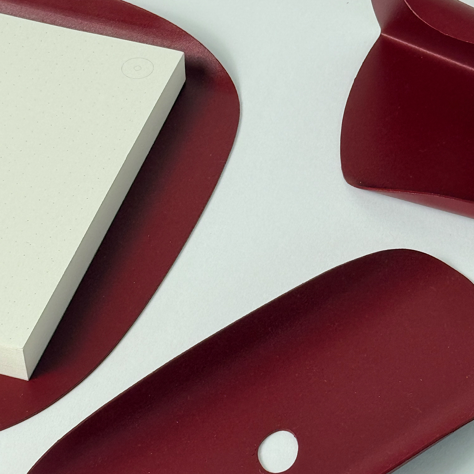 Bordowy organizer biurkowy Flow Set Burgundy Star – zestaw metalowych akcesoriów o rzeźbiarskich kształtach.